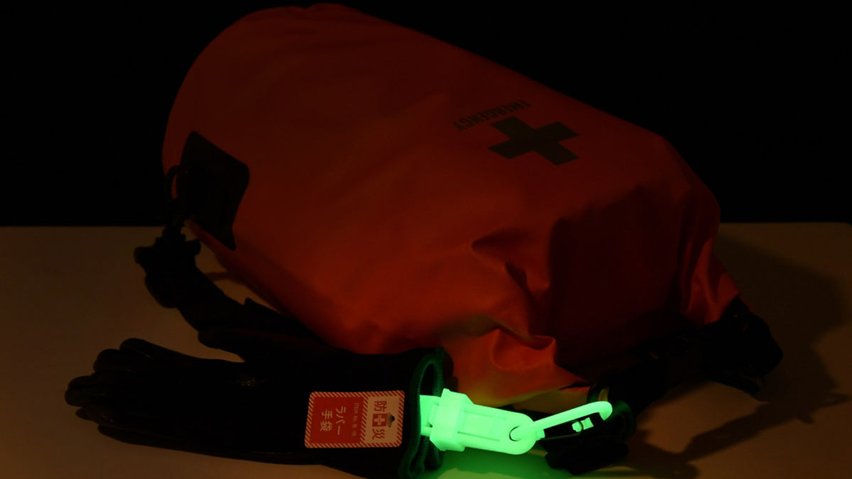 Glowing clip on an emergency bag in the dark