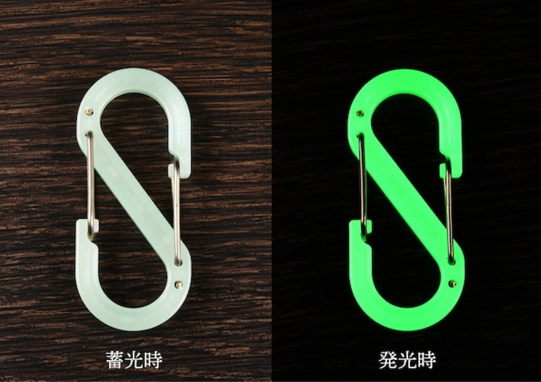 The same S-shaped carabiner in daylight and glowing in the dark