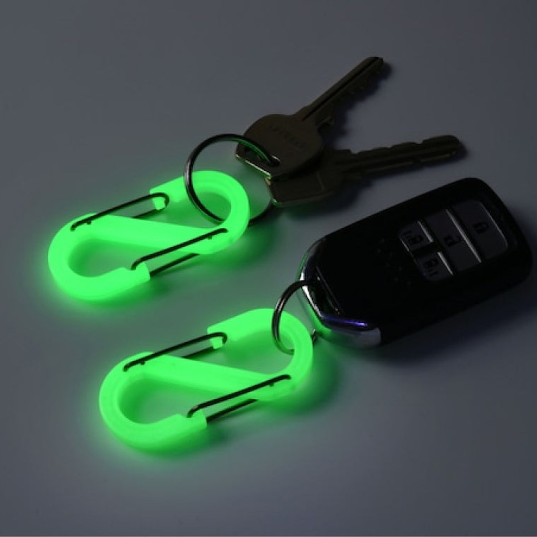 Two glowing OBORO S-shaped carabiners on a car key