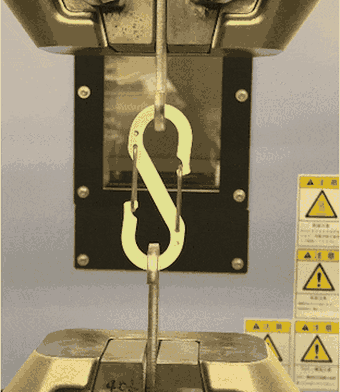 The S-shaped carabiner pulled in a tensile testing machine